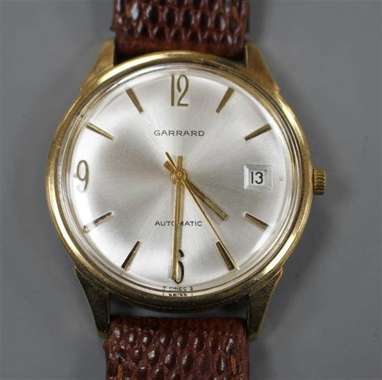 A gentlemans late 1960s 9ct gold automatic wrist watch, retailed by Garrard, with baton numerals and date aperture,
